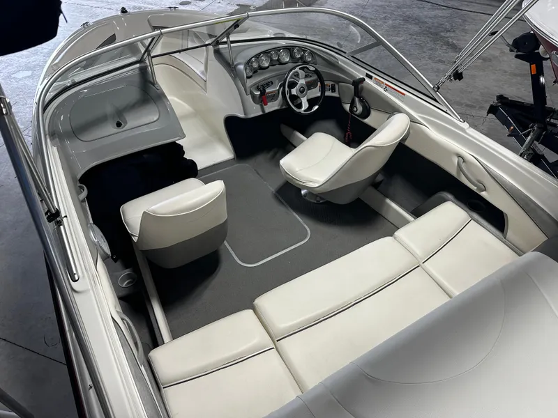 Slide: The Image of 2008 Bayliner 185 boat interior with white seating and steering console. - 14