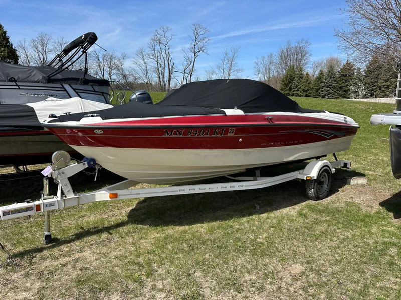 Slide: The Image of 2008 Bayliner 185 boat on trailer, covered, parked on grass. - 2