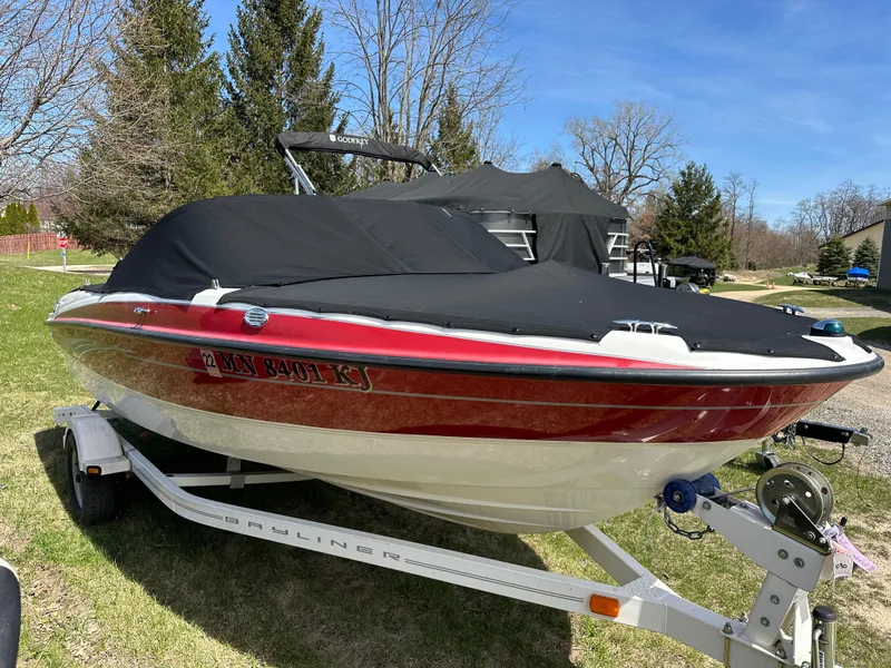 Slide: The Image of 2008 Bayliner 185 boat with cover on trailer, parked on grass. - 4