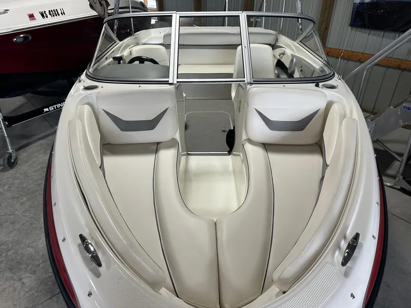 Slide: The Image of 2008 Bayliner 185 boat interior with white seating and windshield in a storage area. - 6
