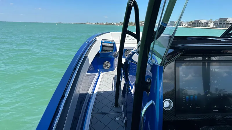 Slide: The Image of 2020 Nor-Tech 390 Sport boat on calm turquoise water, featuring sleek design and modern dashboard. - 10