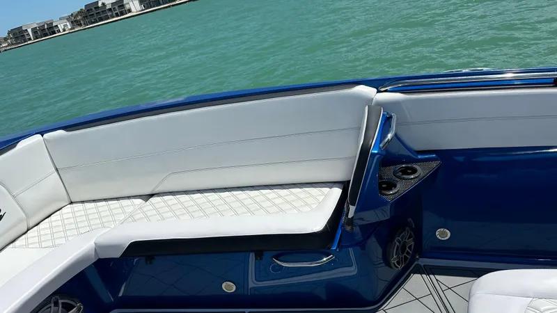 Slide: The Image of 2020 Nor-Tech 390 Sport boat interior with white seating and blue accents on the water. - 13