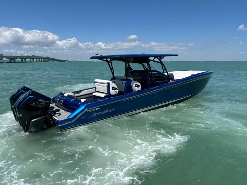 Slide: The Image of 2020 Nor-Tech 390 Sport boat cruising on open water under a clear blue sky. - 4