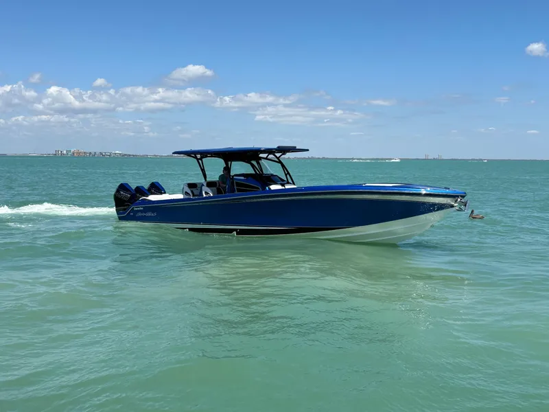 Slide: The Image of 2020 Nor-Tech 390 Sport boat cruising on clear blue water under a sunny sky. - 6