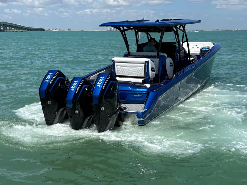 Slide: The Image of 2020 Nor-Tech 390 Sport boat with triple outboard engines cruising on open water. - 9