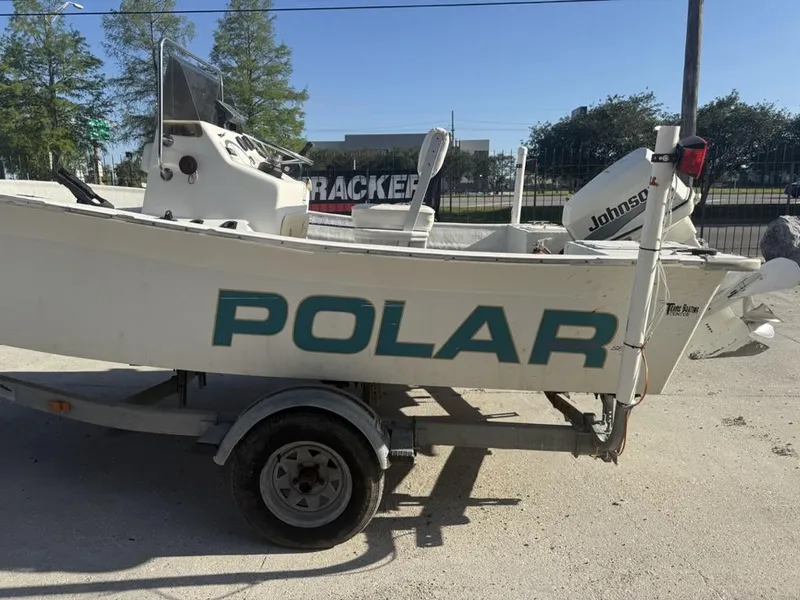 Slide: The Image of 1997 Polar 17 CC boat on trailer with Johnson outboard motor, parked outdoors. - 2