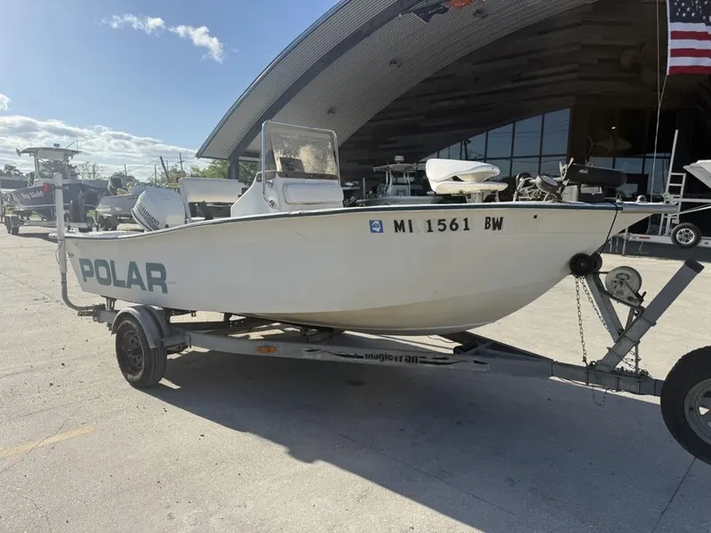 Slide: The Image of 1997 Polar 17 CC boat on trailer, parked outdoors near a building with an American flag. - 5