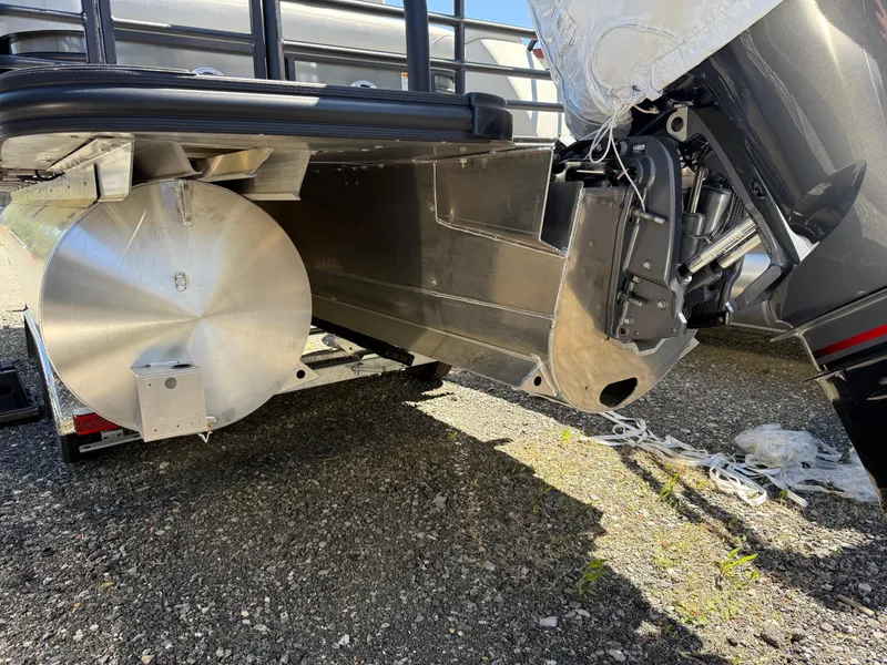 Slide: The Image of 2025 Sylvan L-3 CLZ pontoon boat undercarriage on gravel surface. - 16