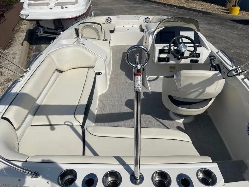 Slide: The Image of 2023 Stingray 212 SC boat interior storage compartments with cooler and seating. - 13