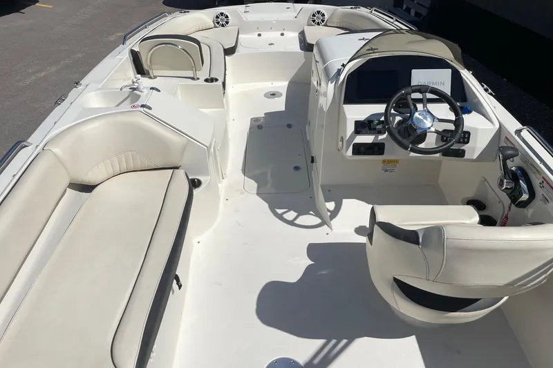 Slide: The Image of 2023 Stingray 212 SC boat interior with white seating and steering console. - 6