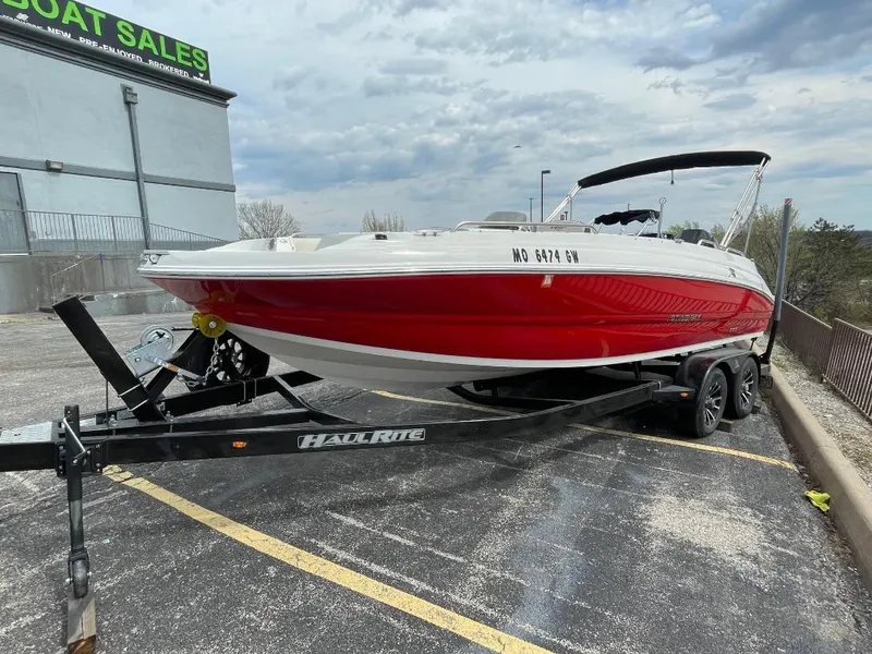 Slide: The Image of 2023 Stingray 212 SC boat interior with white seating and Mercury engine in parking lot. - 9