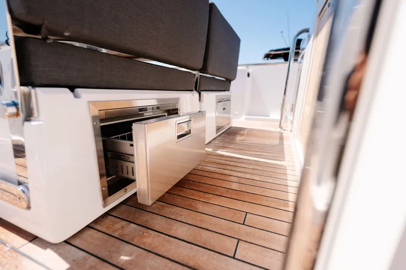 Slide: The Image of 2018 Fjord 36 Xpress boat interior with open storage drawer on wooden deck. - 11