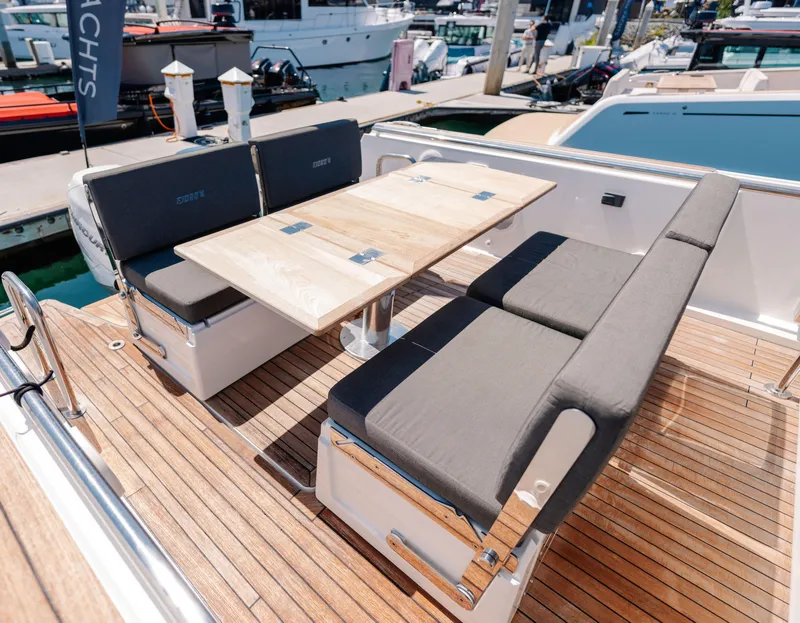 Slide: The Image of Outdoor seating area on a 2018 Fjord 36 Xpress yacht with wooden deck and table. - 12