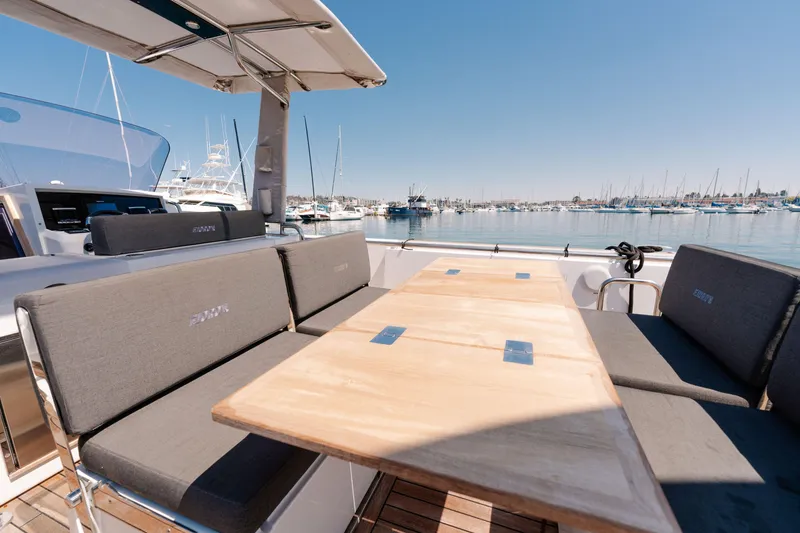 Slide: The Image of Spacious deck of 2018 Fjord 36 Xpress yacht with seating and table, docked at marina. - 13