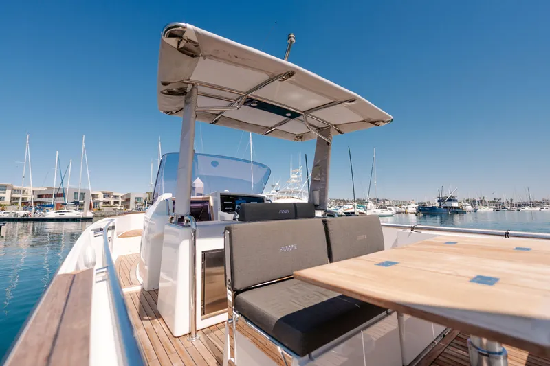 Slide: The Image of 2018 Fjord 36 Xpress yacht with sleek seating and canopy, docked in a marina. - 14