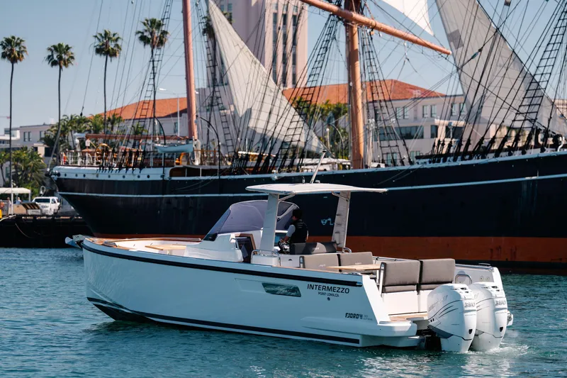 Slide: The Image of 2018 Fjord 36 Xpress boat on water near a historic sailing ship. - 19
