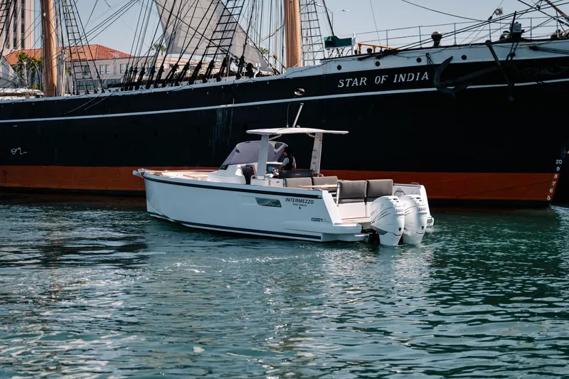 Slide: The Image of 2018 Fjord 36 Xpress boat on water near historic ship, "Star of India." - 23