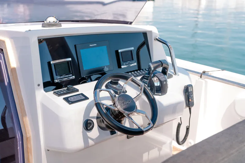 Slide: The Image of Control panel of a 2018 Fjord 36 Xpress boat with steering wheel and navigation equipment. - 27
