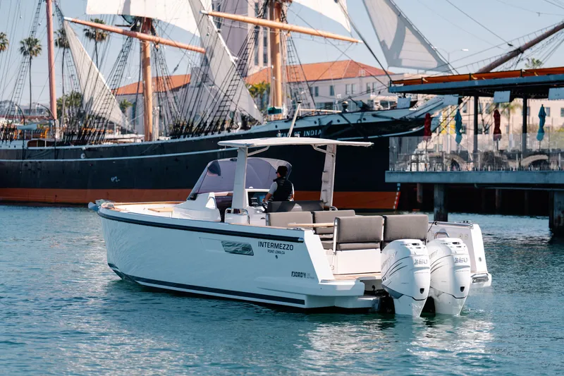 Slide: The Image of 2018 Fjord 36 Xpress boat cruising near historic sailing ships in a marina. - 4