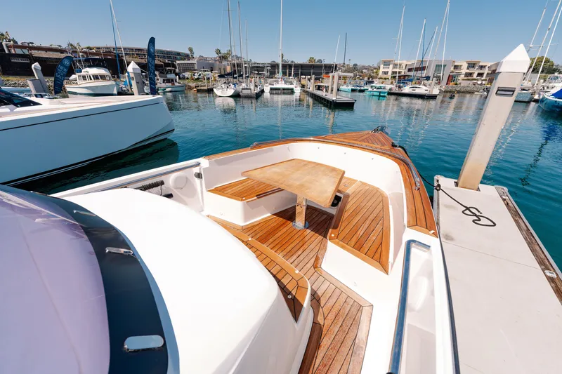 Slide: The Image of 2018 Fjord 36 Xpress boat with wooden deck and seating, docked in a marina. - 8