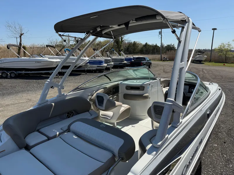 Slide: The Image of 2022 Crownline Eclipse E235 XS boat with canopy, parked outdoors. - 22