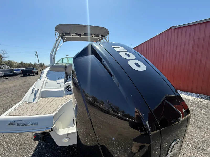 Slide: The Image of 2022 Crownline Eclipse E235 XS boat with powerful 200 HP engine, docked outdoors. - 3