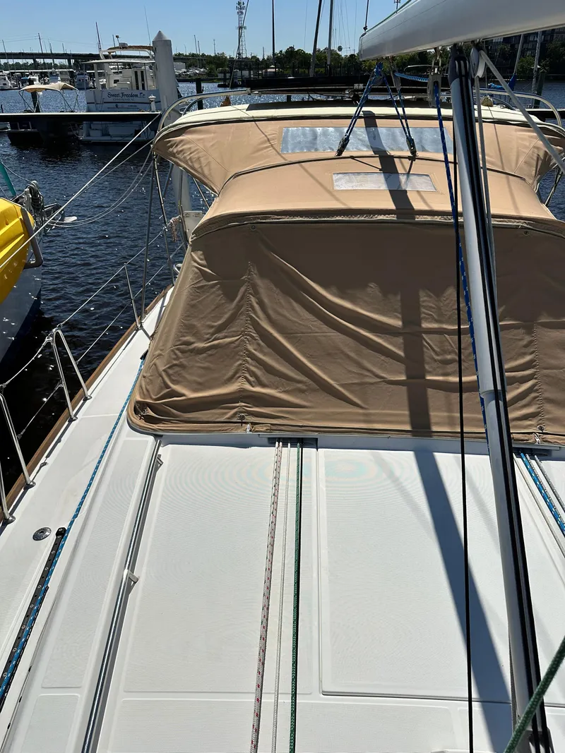 Slide: The Image of 2012 Beneteau Oceanis 41 sailboat deck with tan canopy in marina. - 14