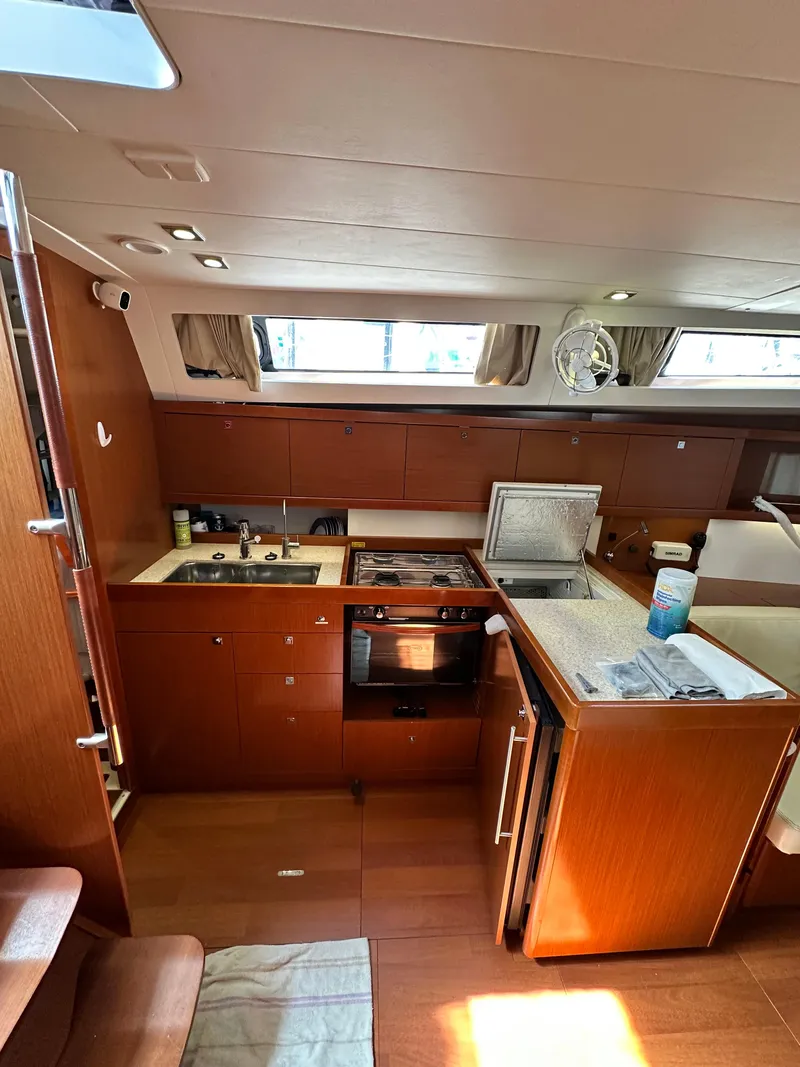Slide: The Image of Interior of 2012 Beneteau Oceanis 41 yacht kitchen with wood finish and modern appliances. - 31
