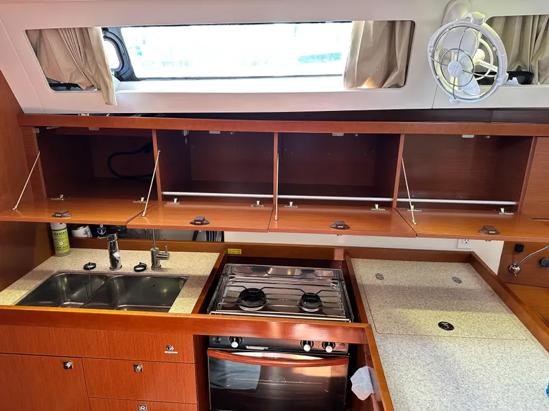 Slide: The Image of Interior of 2012 Beneteau Oceanis 41 yacht kitchen with sink, stove, and storage cabinets. - 42