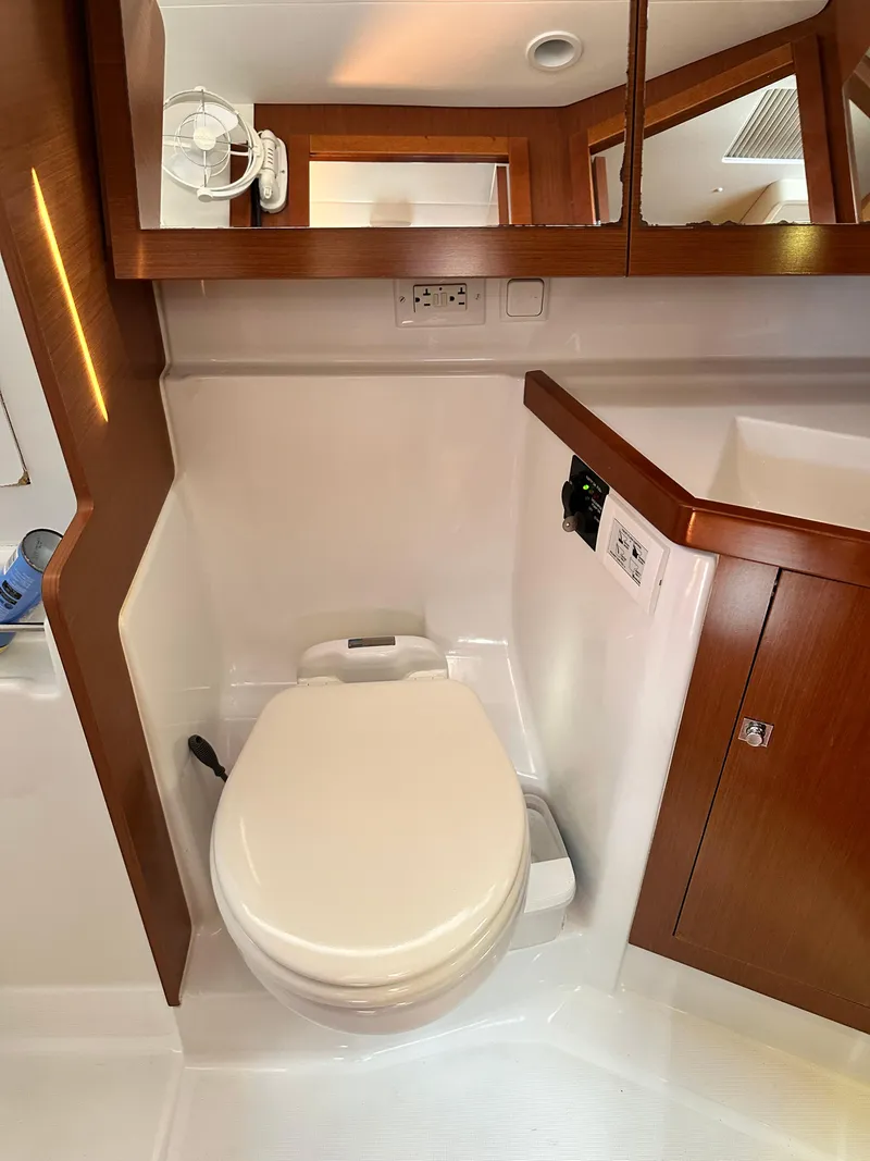 Slide: The Image of Beneteau Oceanis 41 (2012) yacht bathroom with toilet and wooden cabinetry. - 44