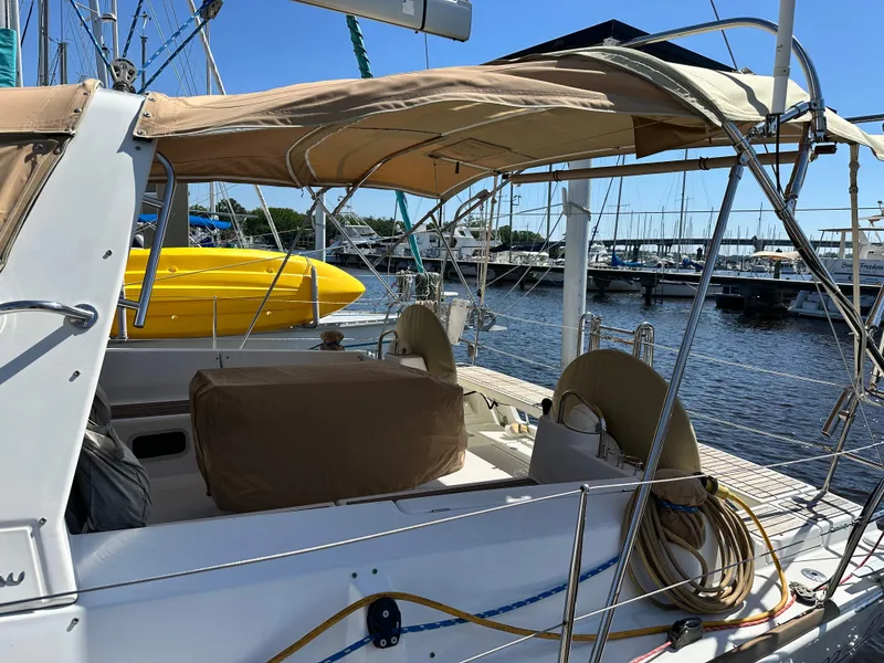 Slide: The Image of 2012 Beneteau Oceanis 41 sailboat docked, featuring a covered cockpit and marina view. - 8