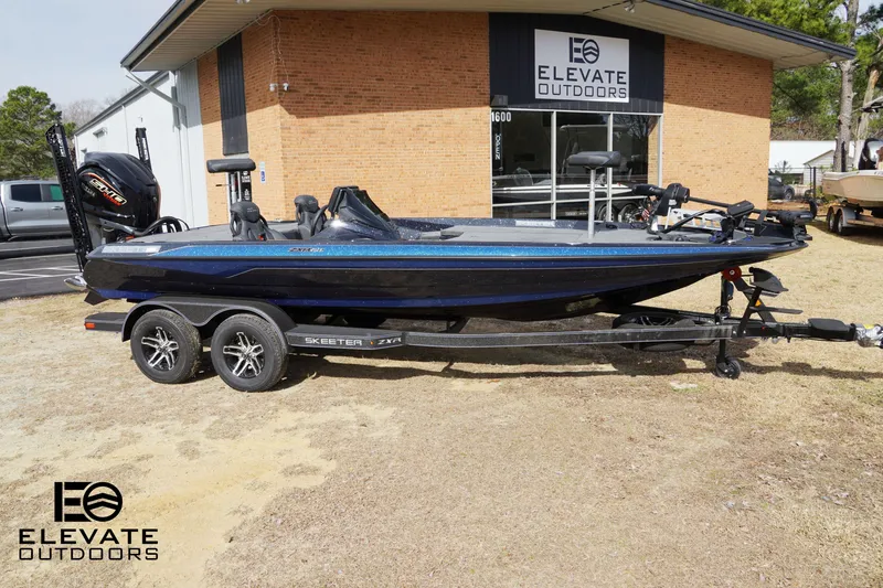 Slide: The Image of 2025 Skeeter ZXR 20 boat on trailer outside Elevate Outdoors store. - 6