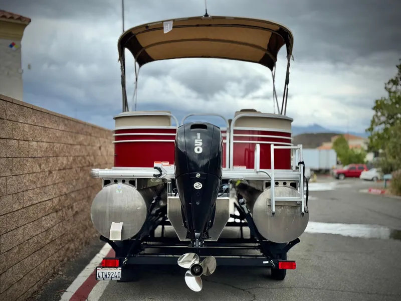 Slide: The Image of 2021 Sun Tracker Party Barge 22 DLX XP3 pontoon boat with 150 HP engine, parked on trailer. - 5