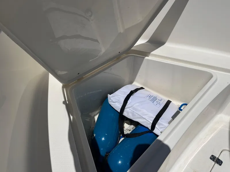 Slide: The Image of Open storage compartment on 2020 Bulls Bay 230 Center Console boat with blue fenders. - 20
