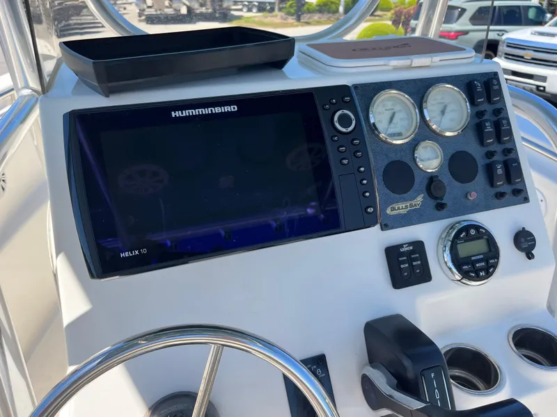 Slide: The Image of 2020 Bulls Bay 230 Center Console dashboard with Humminbird Helix 10 and gauges. - 30