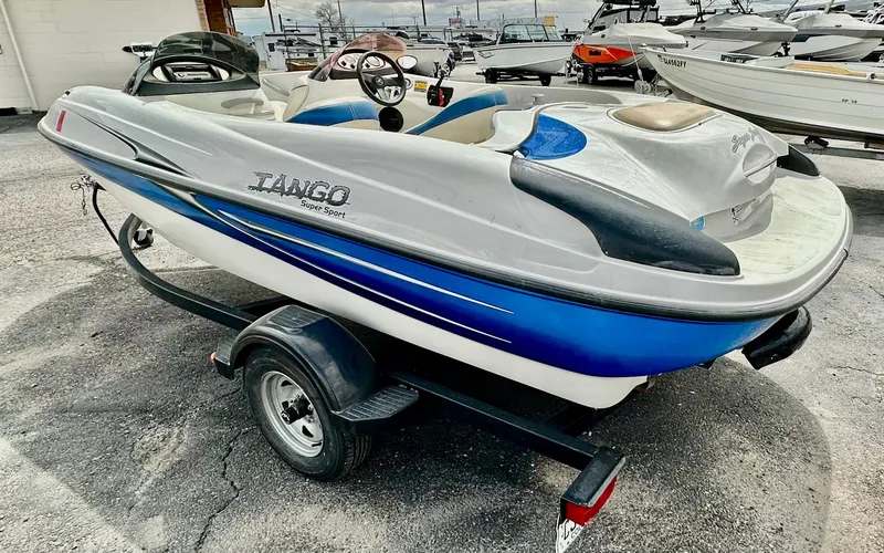 Slide: The Image of 2007 Tango Super Sport boat on trailer, blue and white design, parked outdoors. - 2