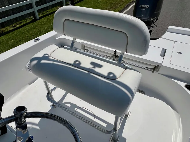 Slide: The Image of 2013 Sportsman Masters 227 Bay Boat with white cushioned seating and steering wheel. - 10