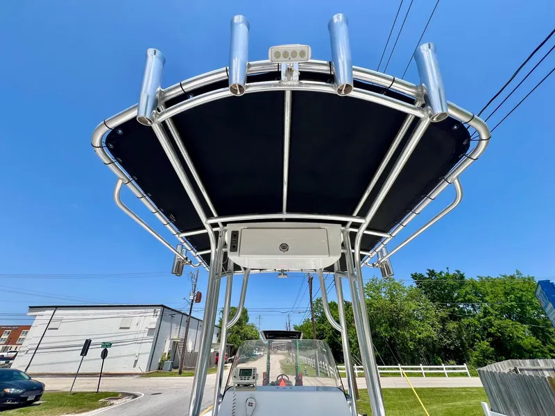 Slide: The Image of 2013 Sportsman Masters 227 Bay Boat with T-top and rod holders under clear blue sky. - 12