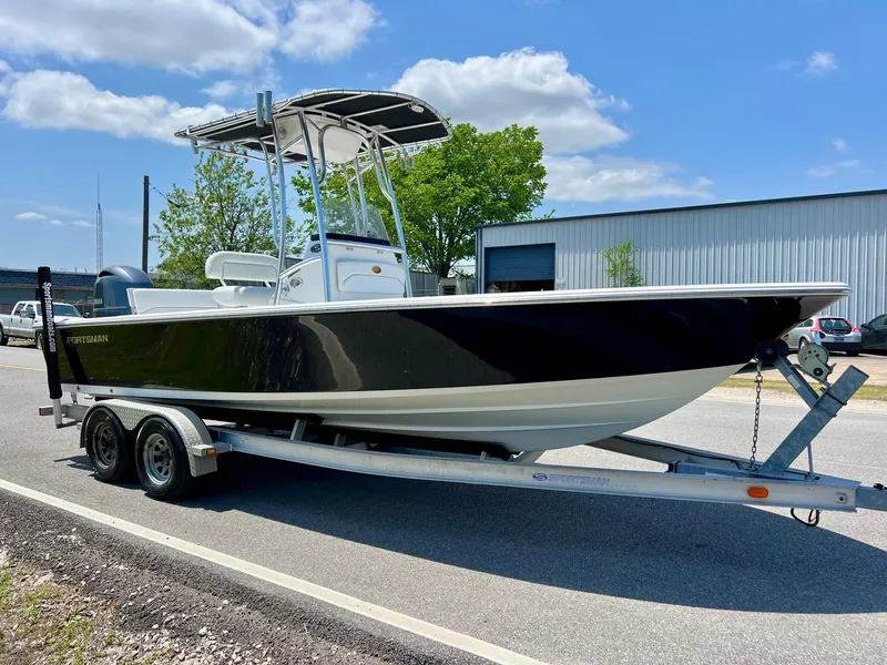 Slide: The Image of 2013 Sportsman Masters 227 Bay Boat on trailer, parked outdoors under blue sky. - 5