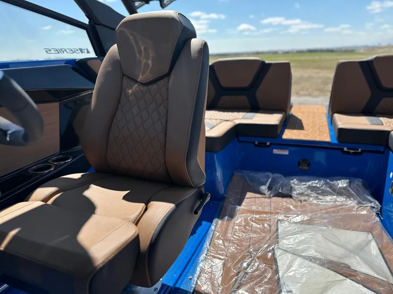 Slide: The Image of 2025 Yamaha Boats 222XE interior with brown seating and blue accents, showcasing modern design. - 10