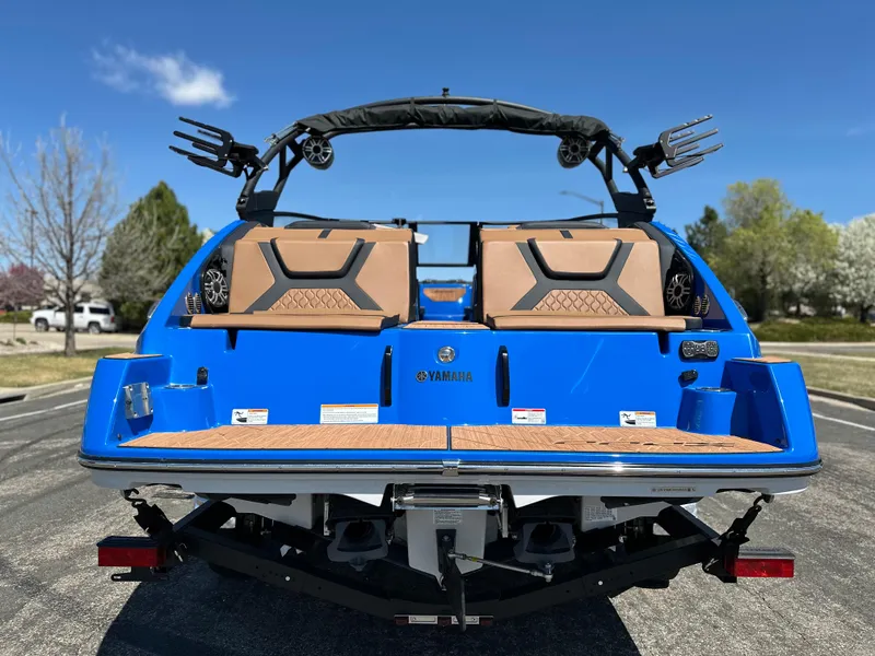 Slide: The Image of 2025 Yamaha Boats 222XE, blue exterior, rear view, parked outdoors on a sunny day. - 3