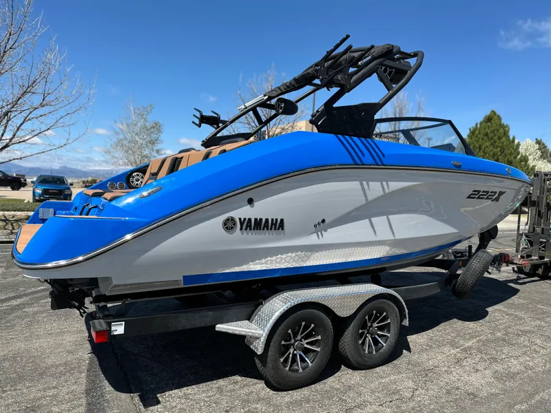Slide: The Image of 2025 Yamaha Boats 222XE on trailer, blue and white design, parked outdoors. - 4