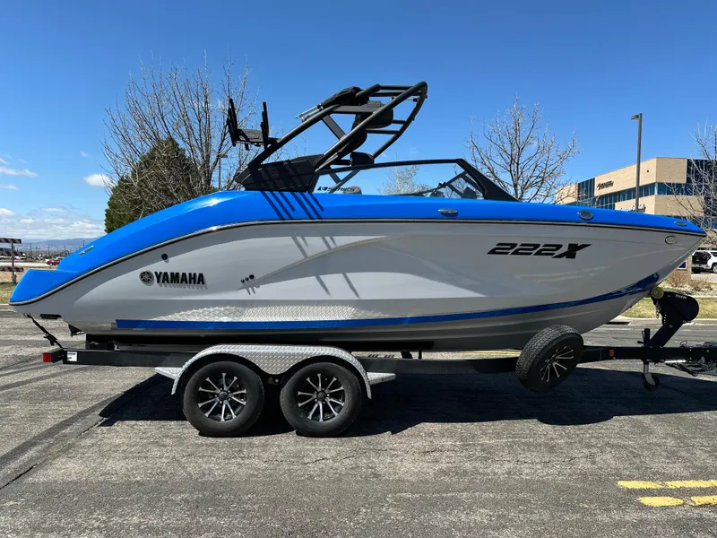 Slide: The Image of 2025 Yamaha Boats 222XE on trailer, blue and white design, parked outdoors. - 5