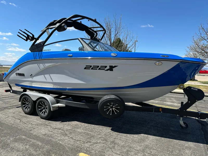 Slide: The Image of 2025 Yamaha Boats 222XE on trailer, blue and white design, parked outdoors. - 6