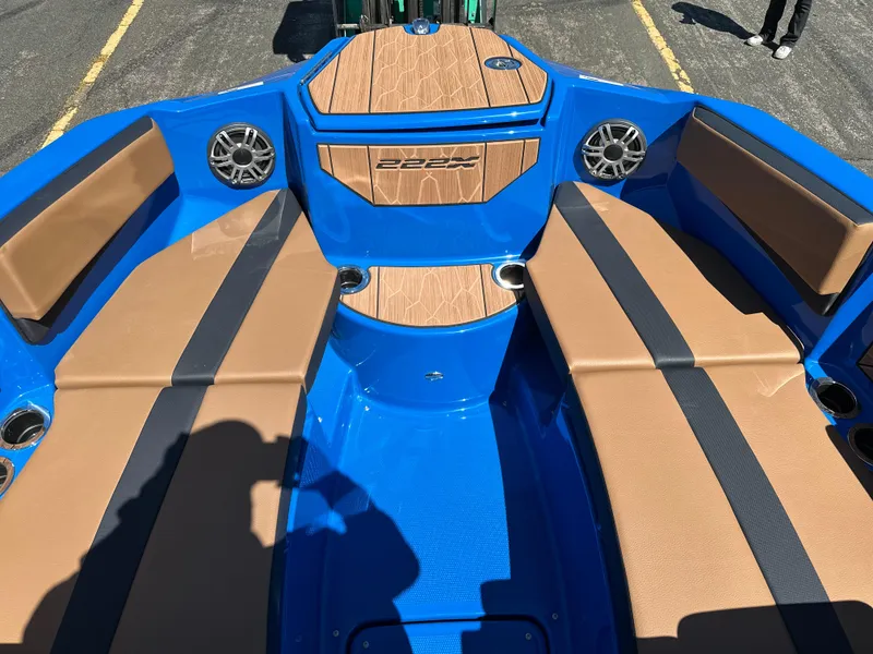 Slide: The Image of 2025 Yamaha Boats 222XE interior with blue and tan seating, speakers, and cup holders. - 7