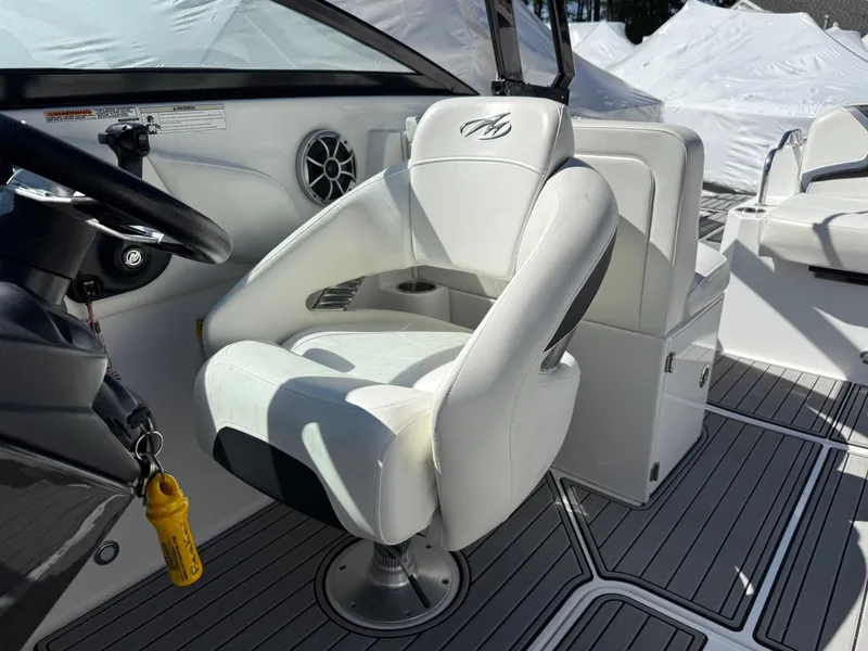 Slide: The Image of 2014 Monterey M5 Sport Boat interior with white captain's chair and steering wheel. - 12