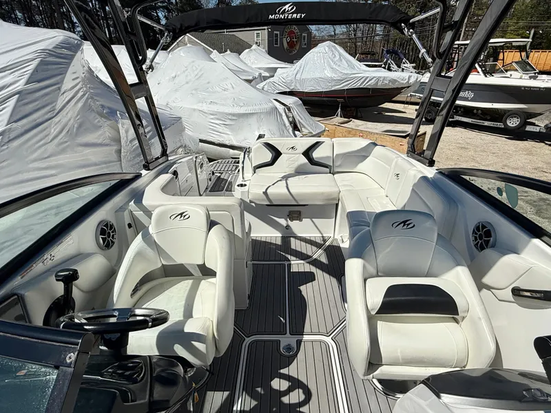 Slide: The Image of 2014 Monterey M5 Sport Boat with white seating and sleek design in a marina setting. - 14