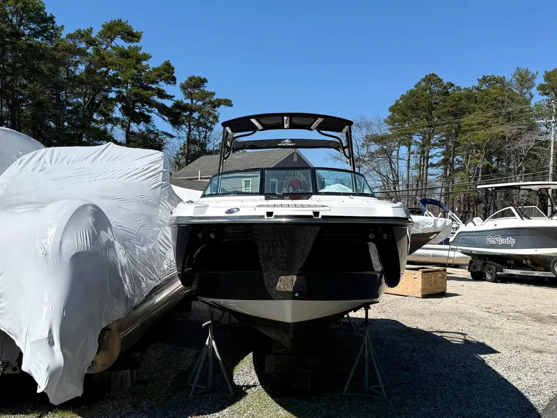 Slide: The Image of 2014 Monterey M5 Sport Boat on stands, surrounded by other boats, under clear blue sky. - 3