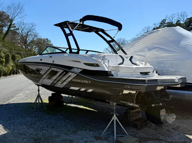 Slide: The Image of 2014 Monterey M5 Sport Boat on stands, black and white design, outdoor setting. - 4