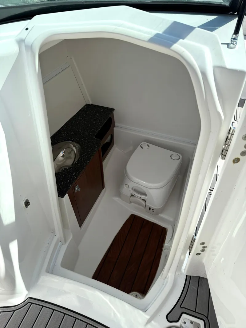 Slide: The Image of 2014 Monterey M5 Sport Boat interior with compact bathroom and wooden flooring. - 8